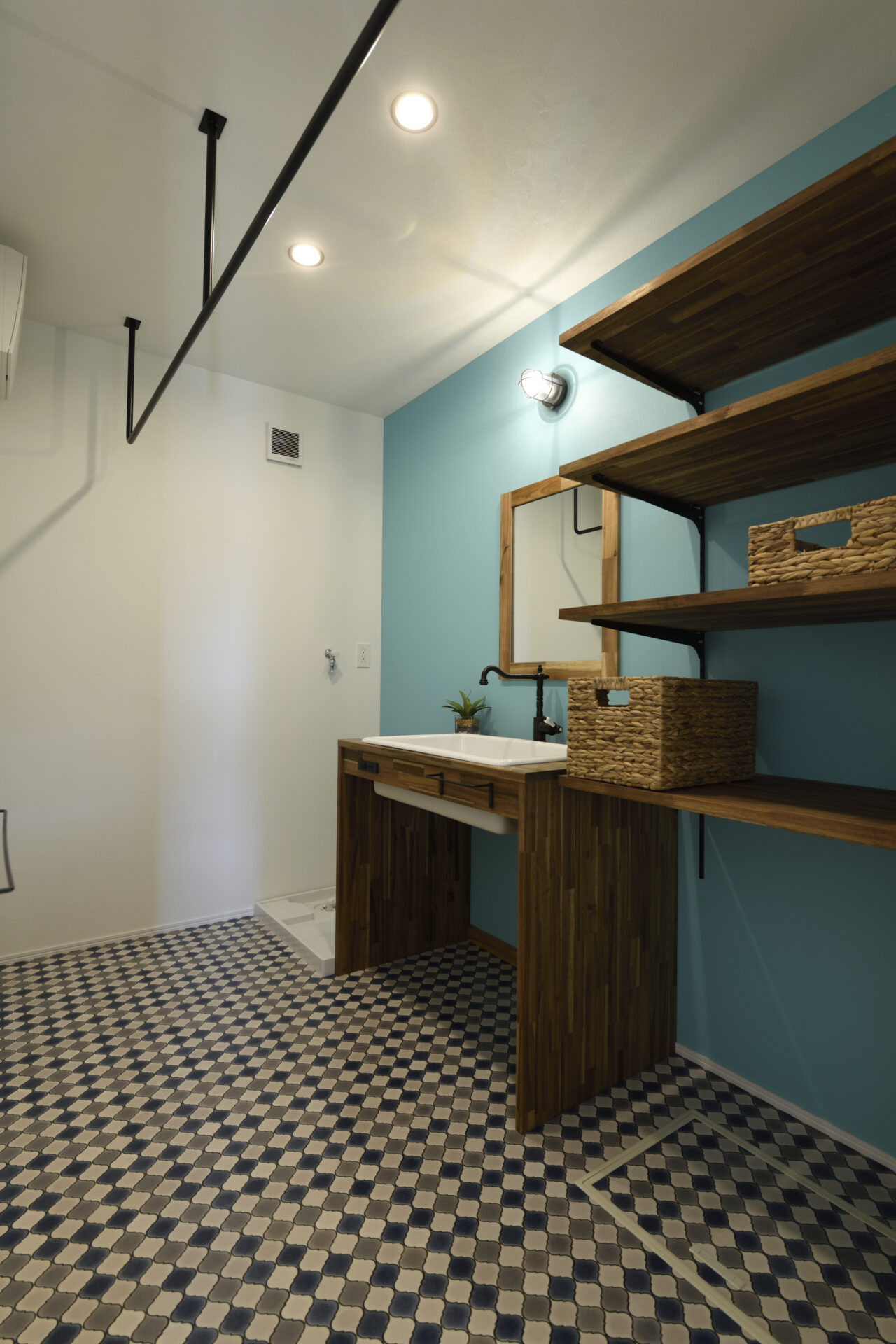 ターコイズブルーの洗面台と市松タイルのサニタリースペース